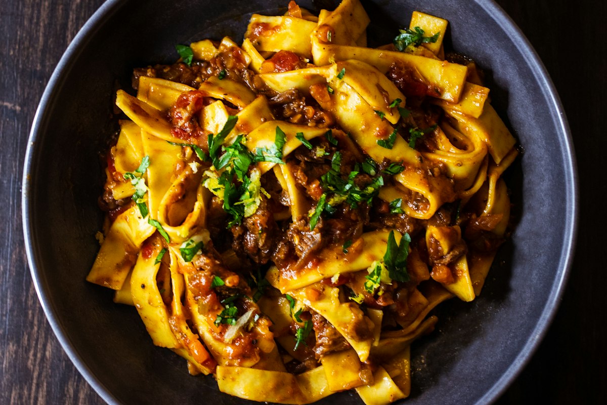 Fresh pappardelle pasta with slow-cooked ragu, served at Merchant of Venice near Calverton