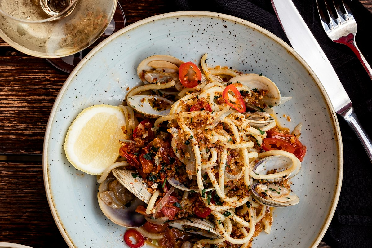 Shared pasta dish at the table, family-style dining at Merchant of Venice Leicester